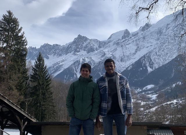 Two group members in front of snowy mountains
