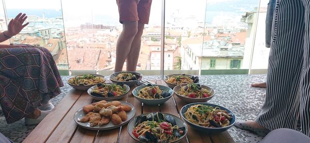 A table of shared dishes on a terrace above the city