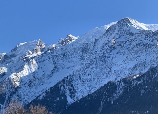 Snow-covered mountain range under a blue sky